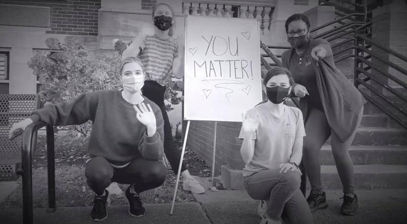 Screenshot from youtube video with teachers pointing at camera with sign that says "You Matter"