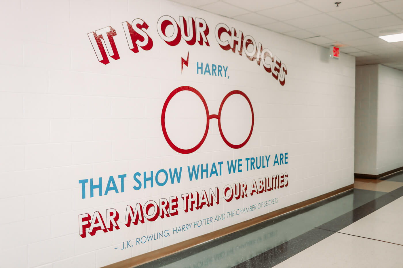 A mural in the school hallway reads "It is our choices Harry, that show what we truly are far more than our abilities" -J.K. Rowling, Harry Potter and The Chamber of Secrets